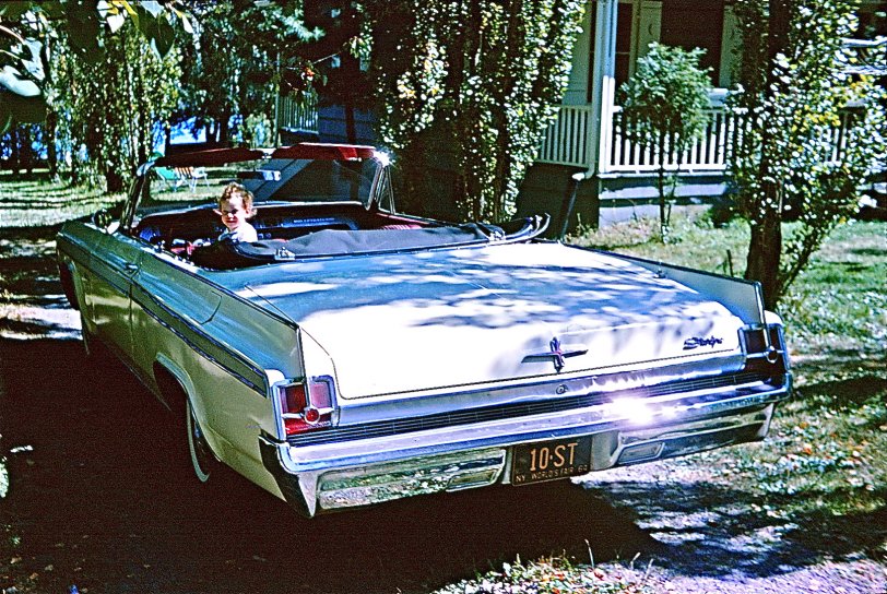 My year-old daughter, Robin, at the wheel of my 1963 Olds Starfire at my in-laws' summer place at Sackett Lake, NY. The vanity plate had my wife's initials and touted the 1964 World's Fair. 35mm Kodachrome slide. View full size.
